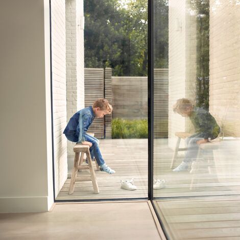 Boy on stool next to Reynaers Aluminium glass corners solution.